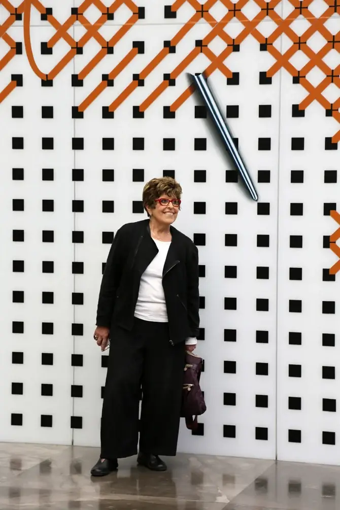 Regina Silveira in front of one of her works